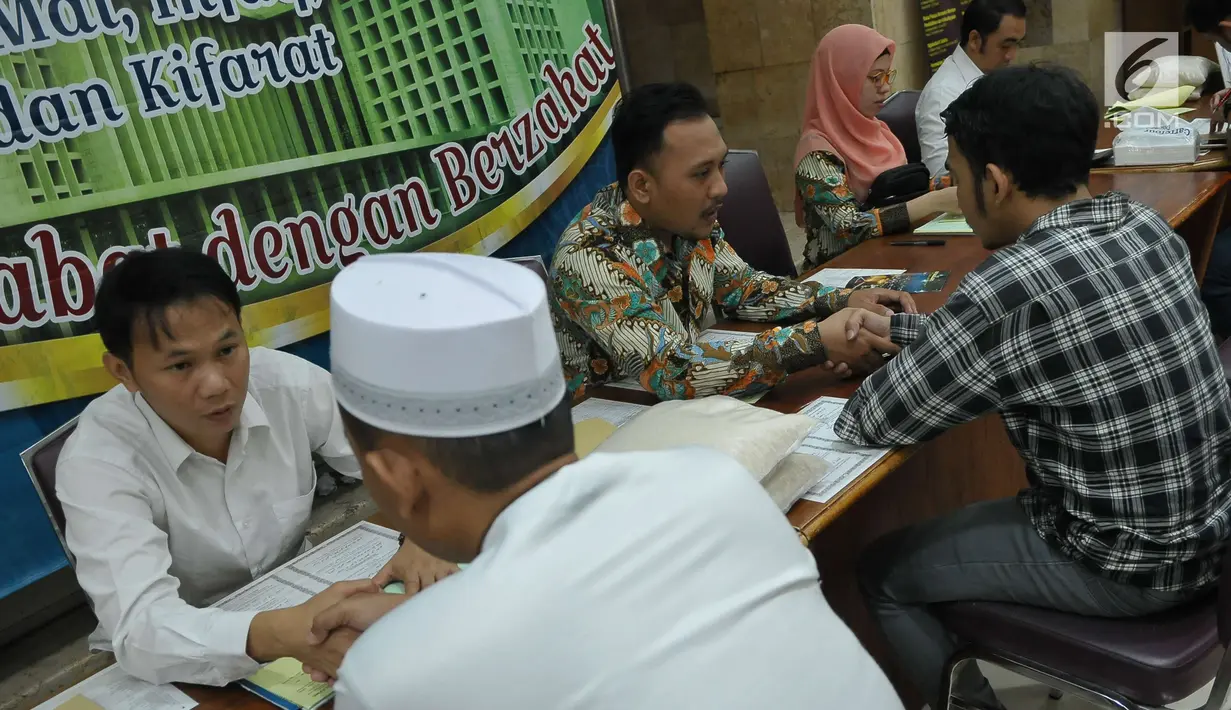 Petugas zakat melakukan ijab penerimaan zakat di Masjid Istiqlal, Jakarta, Jumat (1/7). Waktu pembayaran dibuka hingga malam takbiran dengan pembayaran zakat senilai Rp50ribu dan beras 3,5 liter. (Liputan6.com/Helmi Afandi)