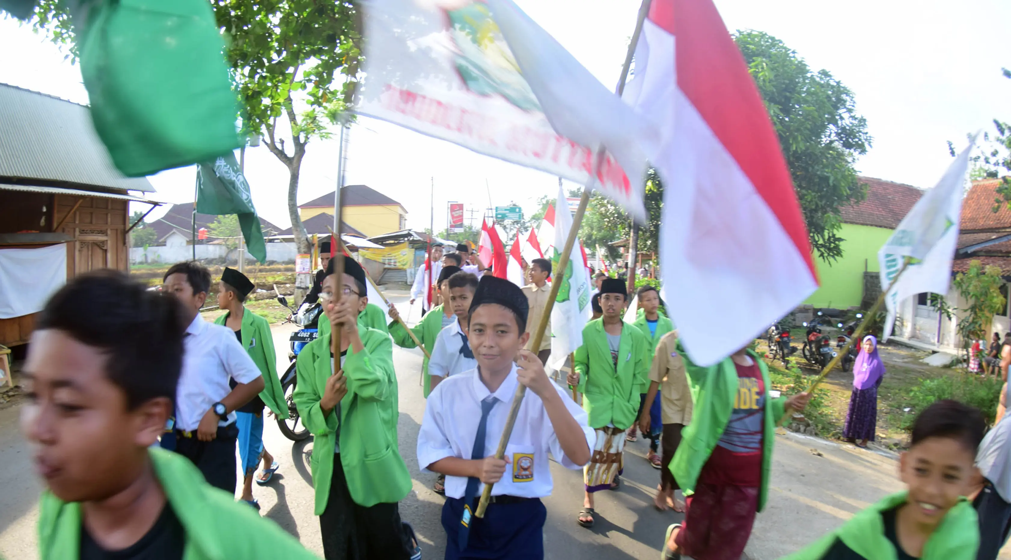Sejumlah santri dari Pondok Pesantren Ashabul Kahfi membawa bendera Merah Putih saat mengikuti pawai Hari Santri Nasional 2017 di Gunungpati, Semarang (22/10). (Liputan6.com/Gholib)