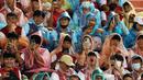 Sejumlah fans Liverpool menggunakan jas hujan saat menyaksikan sesi latihan The Reds di Stadion Rajamangala. (AFP/Jack Taylor)
