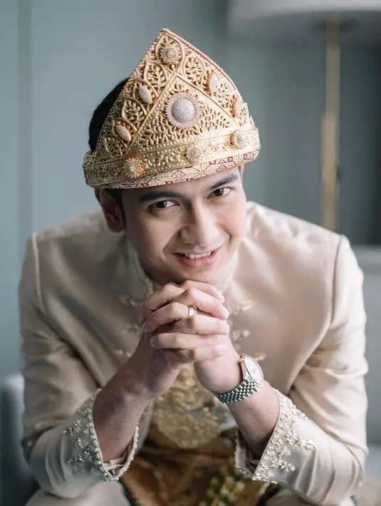 Sebagai hiasan khas pengantin Palembang, Teuku Ryan mengenakan kalung tingkat tiga yang disebut sebagai kebo munggah. (Instagram/imagenic)