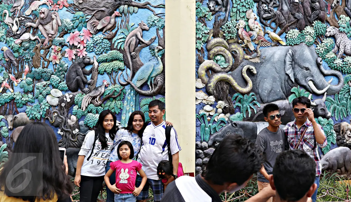 Pengunjung berfoto di kawasan Kebun Binatang Ragunan, Jakarta, Jumat (1/1). Jumlah pengunjung Taman Margasatwa Ragunan pada libur awal tahun 2016 mencapai lebih dari 100.000 orang. (Liputan6.com/Immanuel Antonius)