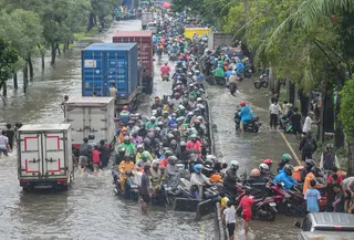 Para pengendara mobil terlihat mengambil jalur paling kanan hingga masuk ke jalur bus Transjakarta guna menghindari titik genangan terdalam di sisi kiri jalan. Tampak dalam foto, antrean pengendara motor yang mencoba menerobos banjir di Jalan Daan Mogot, Jakarta, Jumat (23/1/02026). (merdeka.com/ Arie Basuki)