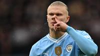 Pemain Manchester City, Erling Haaland membersihkan hidungnya pada laga lanjutan Liga Inggris 2023/2024 melawan Manchester United di Etihad Stadium, Manchester, Inggris, Minggu (03/03/2024) WIB. (AFP/Paul Ellis)