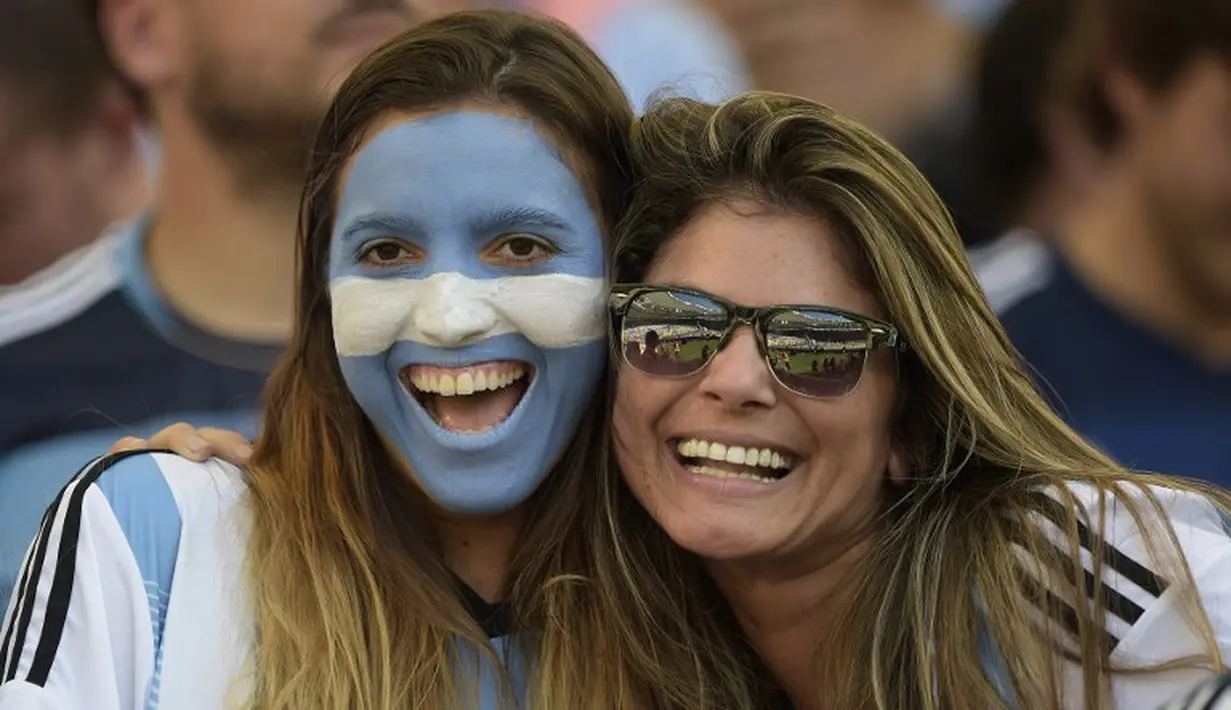 Seorang suporter menghiasi wajahnya dengan coretan warna bendera Argentina saat menyaksikan laga final piala dunia, Brasil, Senin (14/7/14). (AFP PHOTO/JUAN MABROMATA)
