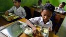 Beberapa siswa menikmati makanan yang disediakan lewat program pemerintah Indonesia, Makan Bergizi Gratis (MBG), di sebuah sekolah dasar di Darul Kamal, Provinsi Aceh pada Senin 13 Oktober 2025. (CHAIDEER MAHYUDDIN/AFP)