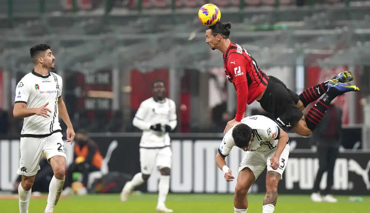 Pemain AC Milan Zlatan Ibrahimovic menyundul bola melewati pemain Spezia Dimitris Nikolaou pada pertandingan sepak bola Liga Italia di Stadion San Siro, Milan, Italia, 17 Januari 2022. AC Milan kalah 1-2. (AP Photo/Luca Bruno)