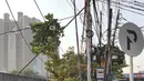 Pejalan kaki melintas di bawah kabel semrawut di sekitar Jalan Gunung Sahari, Mangga Dua, Jakarta, Kamis (10/7/2019). Buruknya tata instalasi kabel di Ibu Kota menjadi penyebab banyaknya kabel semrawut, meskipun kondisi itu berbahaya serta mengganggu pemandangan. (Liputan6.com/Immanuel Antonius)