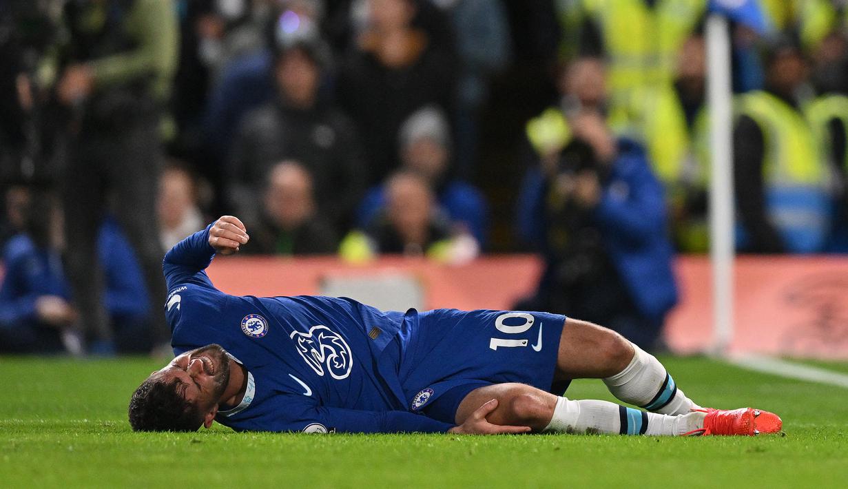 Gelandang Chelsea, Christian Pulisic terbaring di lapangan setelah mengalami cedera di bagian lutut saat menghadapi Manchester City pada laga Liga Inggris 2022/2023 di Stamford Bridge, London (5/1/2023). Akibat sering dilanda cedera membuat penampilannya kurang optimal bersama Chelsea dan imbasnya ia mulai tersisihkan dalam beberapa musim terakhir. Meski kontraknya masih tersisa satu tahun lagi, ia diprediksi akan hengkang pada akhir musim 2022/2023. (AFP/Glyn Kirk)