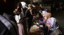 Warga Palestina dari Jalur Gaza diperiksa identitasnya saat tiba di pusat distribusi untuk mengambil kotak bantuan makanan yang disediakan oleh Program Pangan Dunia (WFP), di desa Al-Zawayda, di tengah Jalur Gaza pada 27 Oktober 2025. (BASHAR TALEB/AFP)