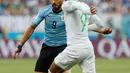 Penyerang Uruguay, Luis Suarez berebut bola dengan pemain Arab Saudi Hatan Bahbir pada pertandingan kedua Grup A Piala Dunia 2018 di Rostov Arena, Rabu (20/6). Uruguay mengalahkan Arab Saudi 1-0 berkat gol Suarez di babak pertama. (AP/ Darko Vojinovic)