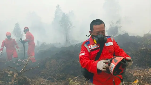 Proses pemadaman kebakaran lahan di Riau yang dilakukan petugas gabungan.
