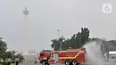 Petugas pemadam kebarakan menyemprotkan cairan disinfektan di kompleks Monumen Nasional (Monas), Jakarta, Senin (30/3/2020). Penyemprotan disinfektan ini dilakukan guna memutus rantai penyebaran virus Corona atau Covid-19 di pusat kota. (merdeka.com/Iqbal S. Nugroho)