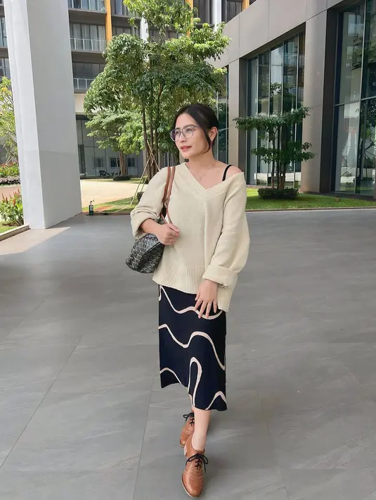 Kali ini, Prilly Latuconsina dalam balutan busana chic yang kasual. Ia mengenakan atasan rajut berwarna cokelat muda dengan midi skirt berwarna biru navy bermotif abstrak. Rambutnya digulung ke bekalang dan ia kembali memakai kacamata yang membuatnya tampil semakin manis. [Foto: Instagram/prillylatuconsina96]