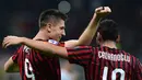 Pemain AC Milan, Krzysztof Piatek, bersama Hakan Calhanoglu, merayakan gol ke gawang Lecce pada laga Serie A Italia di Stadion San Siro, Milan, Minggu (20/10). Kedua klub bermain imbang 2-2. (AFP/Miguel Medina)