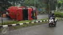 Warga melihat kondisi truk tangki BBM yang terbalik di ruas Jalan Tegar Beriman Kabupaten Bogor, Jumat (15/4/2016). Truk tangki yang terbalik dalam kondisi penuh muatan BBM jenis premium. (Liputan6.com/Helmi Fithriansyah)