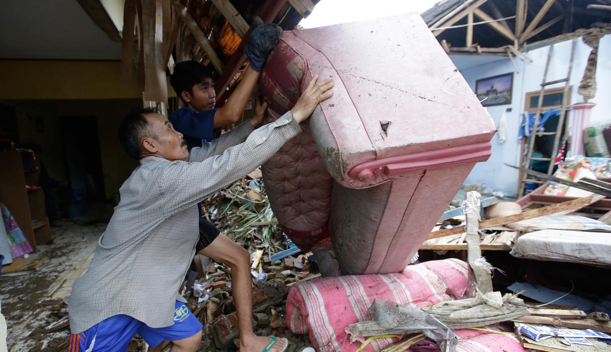 Warga lokal Alimin membersihkan puing-puing dari rumahnya setelah tsunami di Carita, Banten, Kamis, (27/12). Pemerintah telah memperluas zona larangan di sekitar pulau gunung berapi pulau yang memicu tsunami. (AP Photo/Achmad Ibrahim)