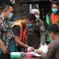 Petugas Satpol PP mendata warga yang terjarinng razia masker di kawasan Tanjung Duren, Jakarta, Kamis (19/11/2020). Satpol PP terus menindak warga yang melanggar protokol kesehatan selama PSBB transisi dengan sanksi kerja sosial di sarana umum atau membayar denda. (merdeka.com/Imam Buhori)