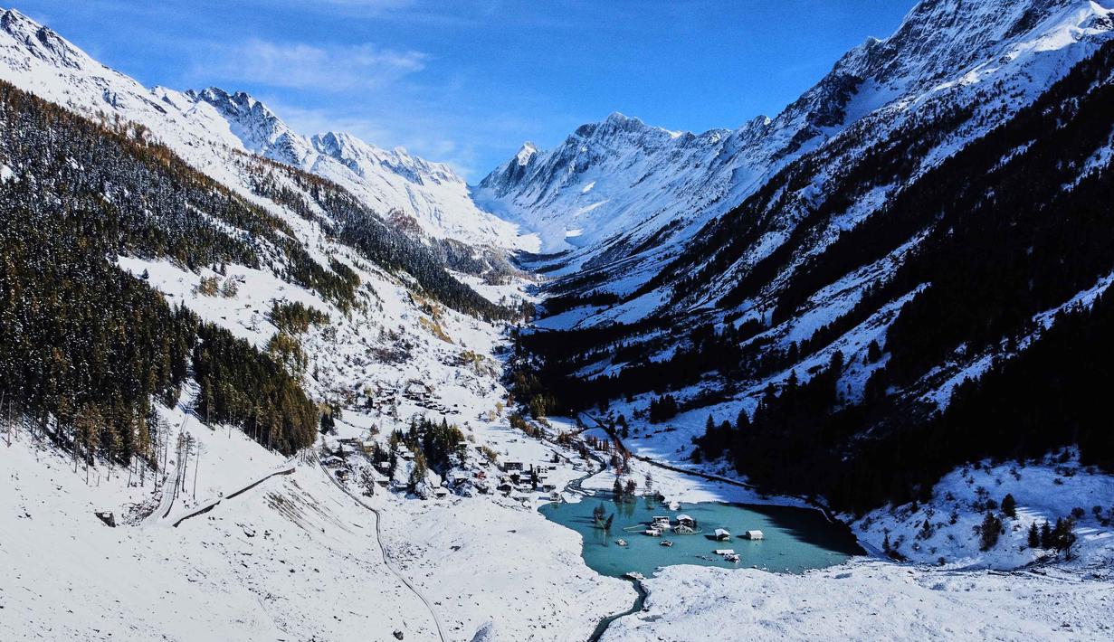 Pemandangan udara menunjukkan Desa Blatten yang sebagian terendam banjir setelah hujan salju baru-baru ini, lima bulan setelah tanah longsor menghancurkan desa tersebut, Blatten, Swiss, pada Selasa 28 Oktober 2025. Beberapa rumah kembali terlihat di permukaan. (AP Photo/Michael Probst)