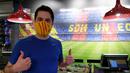 Fans memakai masker berlogo Barcelona di Toko Asesoris Barcelona, Senin (25/5/2020). Di tengah pandemi virus Corona, Barcelona menjual masker dengan harga 18 euro atau sekitar Rp 291 ribu. (AFP/Lluis Gene)