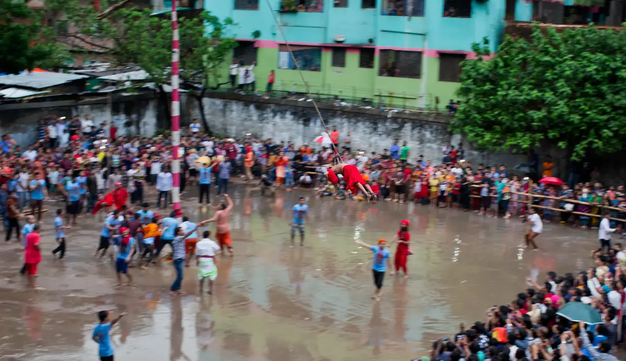 Seorang penganut Hindu tergantung dengan kaitan yang ditusuk di punggungnya saat festival Charak Puja di Dhaka, Bangladesh (14/4). Orang-orang Hindu percaya bahwa festival akan membawa kemakmuran. (AP Photo / A.M. Ahad)