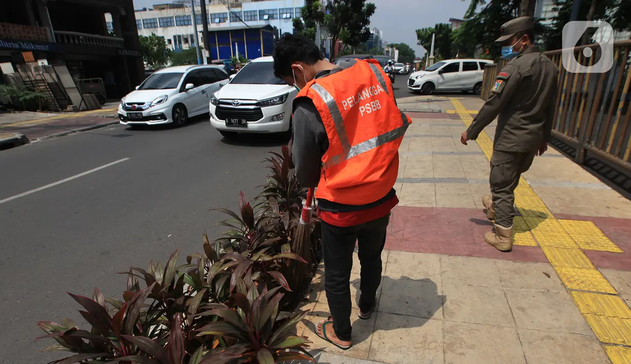 Warga yang terjaring razia masker mendapat hukuman petugas Satpol PP di kawasan Tanjung Duren, Jakarta, Kamis (19/11/2020). Satpol PP terus menindak warga yang melanggar protokol kesehatan selama PSBB transisi dengan sanksi kerja sosial di sarana umum atau membayar denda. (merdeka.com/Imam Buhori)