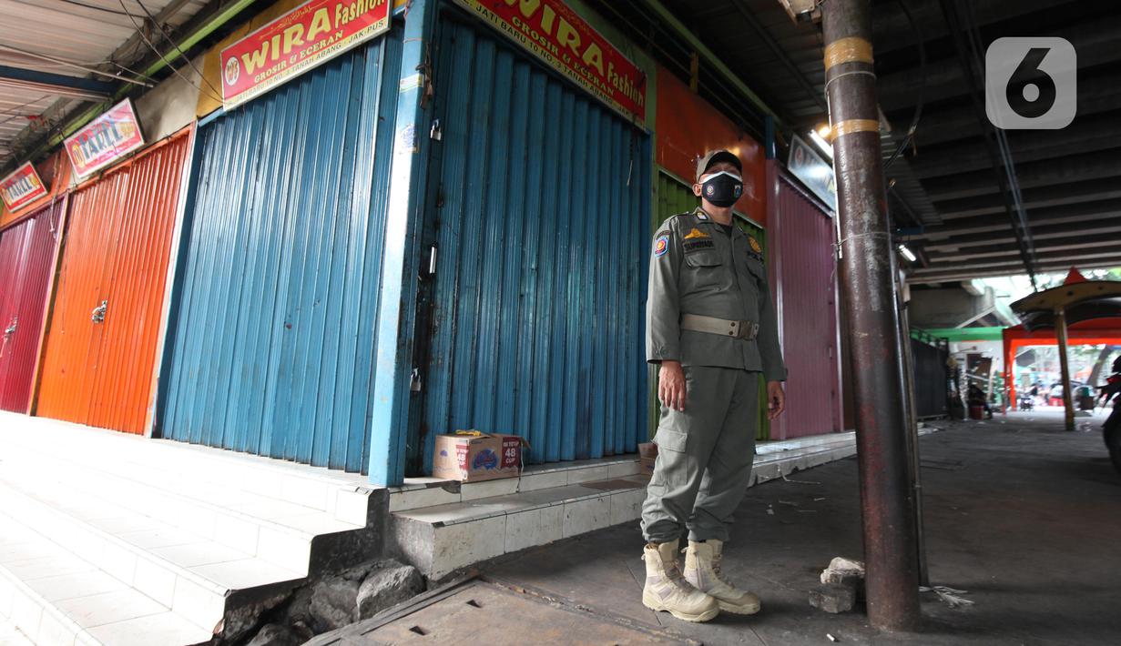 Petugas Satpop PP berjaga di kawasan Pasar Tanah Abang, Jakarta, Rabu (7/7/2021). Satpol PP melakukan penjagaan di seluruh Pasar Tanah Abang mengantisipasi pedagang yang membandel tetap berjualan saat diberlakukannya PPKM Darurat. (Liputan6.com/Angga Yuniar)