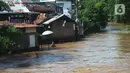 Warga melintasi banjir di Bukit Duri, Jakarta, Jumat (29/10/2021). Hujan dengan intensitas tinggi beberapa hari lalu membuat aliran sungai ciliwung meluap yang merendam sebagian rumah warga yang tinggal di bantaransungai  tersebut. (merdeka.com/Imam Buhori)