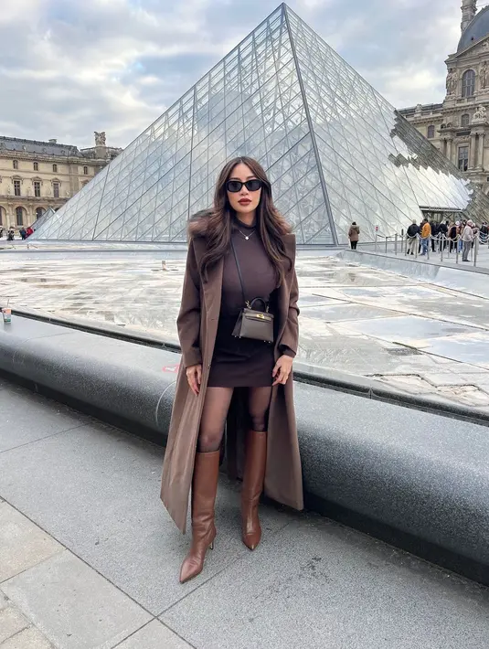 Saat liburan di Paris, Kezia Toemion tampil seperti warga lokal dengan Parisian Chic look. Ia mengenakan mini dress cokelat dengan long coat dan high leather boots. Lengkapi outfitnya, ia mengalungkan tas Hermes berwarna cokelat gelap. [@keziatoemion]