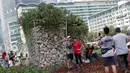 Warga berfoto di area taman dekat Instalasi Gabion saat CFD di kawasan Bundaran Hotel Indonesia, Jakarta, Minggu (25/8/2019). Instalasi Gabion berdiri di lokasi bekas seni anyaman bambu Getah Getih dan diletakkan bebatuan sebagai penghias. (Liputan6.com/Helmi Fithriansyah)