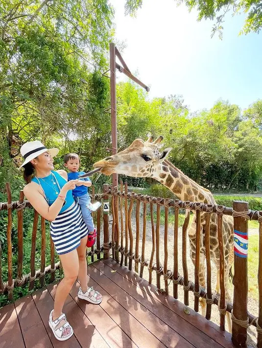 Di tengah kesibukannya, Ayu Dewi masih menyempatkan diri untuk liburan bareng keluarga. Mengajak keluarganya ke kebun binatang, Ayu Dewi mengenakan halter cutout top berwarna biru yang dipadukan dengan striped skirt.  (instagram/ayudewi7984)