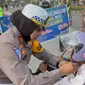 Kasat Lantas Polres Pelalawan AKP Akira Ceria memberikan helm kepada anak-anak dalam rangka Operasi Keselamatan Lancang Kuning jelang Ramadan. (Liputan6.com/M Syukur)