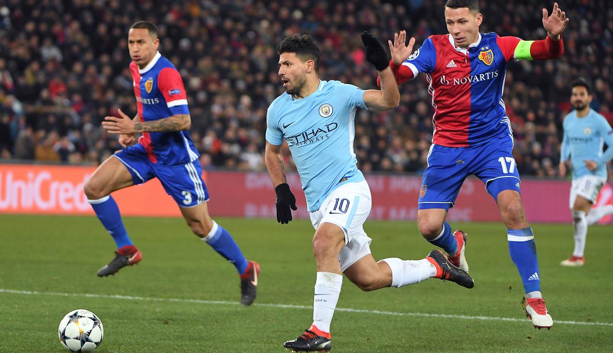 Aksi pemain Manchester City, Sergio Aguero (tengah) melewati adangan pemain Basel, Marek Suchy pada laga 16 besar Liga Champions di Saint Jakob-Park Stadium, Basel, (13/2/2018). Manchester City menang 4-0. (AFP/Patrick Hertzog)