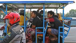 Sejumlah warga menaiki bak terbuka motor roda tiga menuju Kebun Binatang Ragunan di kawasan Jakarta, Minggu (9/6/2019). Warga memanfaatkan motor roda tiga untuk bepergian bersama keluarga menuju sejumlah objek wisata karena dianggap lebih hemat biaya. (Liputan6.com/Herman Zakharia)