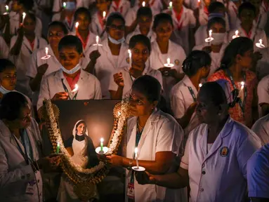 Petugas kesehatan menyalakan lilin untuk menandai Hari Perawat Internasional di sebuah perguruan tinggi kedokteran pemerintah di Chennai, India, Jumat (12/5/2023). (R.Satish Babu/AFP)