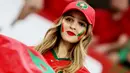 Fans Maroko tersenyum saat menyaksikan laga Maroko melawan Spanyol pada laga Piala Dunia 2022 di Stadion Education City, Selasa (6/12/2022). (AFP/Jack Guez)