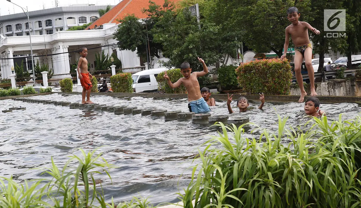 Anak-anak bermain di kolam air mancur penghias kawasan Pasar Baru, Jakarta, Selasa (29/1). Keterbatasan lahan bermain menyebabkan sebagian anak di Ibukota bermain tidak pada tempatnya, meskipun berbahaya bagi keselematan. (Liputan6.com/Immanuel Antonius)
