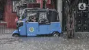 Sebuah bajaj saat terjebak banjir yang merendam Jalan Abdullah Syafei, Tebet, Jakarta, Kamis (18/2/2021). Banjir juga menyebabkan akses putar balik di kawasan dekat Stasiun Tebet itu terputus. (merdeka.com/Iqbal S Nugroho)