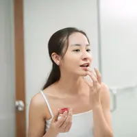 Ilustrasi perempuan sedang merawat bibir. &copy;makidotvn/depositphotos.com