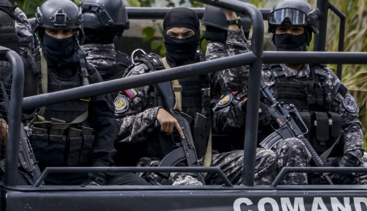 Anggota Bolivarian National Intelligence Service (SEBIN) berpatroli untuk menangkap Oscar Perez di Caracas, Venezuela, Senin (15/1). Oscar Perez merupakan pilot yang menjatuhkan granat di Mahkamah Agung (MA) Venezuela tahun lalu. (AFP PHOTO/JUAN BARRETO)