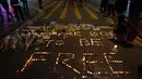 Para pengunjuk rasa menggunakan lilin untuk membentuk kata-kata "Kita dilahirkan untuk bebas" saat memberi penghormatan untuk mahasiswa Alex Chow Tsz-lok yang tewas di Hong Kong (8/11/2019). (AP Photo/Vincent Yu)