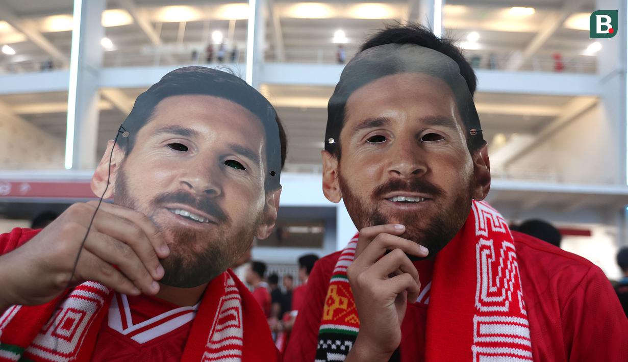 Dua suporter mengenakan topeng Lionel Messi berpose di depan fotografer sebelum laga FIFA Matchday antara Timnas Indonesia melawan Argentina di Satdion Utama Gelora Bung Karno (SUGBK), Senayan, Jakarta, Senin (19/06/2023). (Bola.com/Bagaskara Lazuardi)
