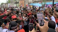 Istri calon presiden Ganjar Pranowo, Siti Atikoh Supriyanti, disambut meriah ratusan warga di Gang Tegal, RW XI, Kutoarjo ketika dalam perjalanan dari Purworejo menuju Banyumas, Jawa Tengah, Kamis (28/12/2023). (Liputan6.com/Delvira Hutabarat)