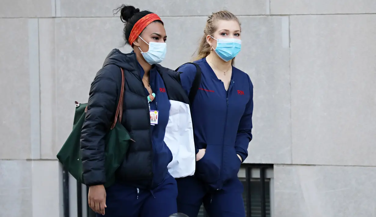 Dua pekerja medis tiba untuk giliran kerja di NewYork-Presbyterian Hospital / Weill Cornell Medical Center selama pandemi COVID-19 di New York City (21/4/2020). (Cindy Ord/Getty Images/AFP)
