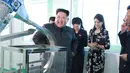 Gambar tak bertanggal yang dirilis kantor berita KCNA pada 29 Oktober 2017 memperlihatkan pemimpin Korea Utara, Kim Jong-Un ditemani istrinya, Ri Sol-Ju, tersenyum ketika memeriksa pabrik kosmetik di Pyongyang. (AFP PHOTO / KCNA VIA KNS / STR)