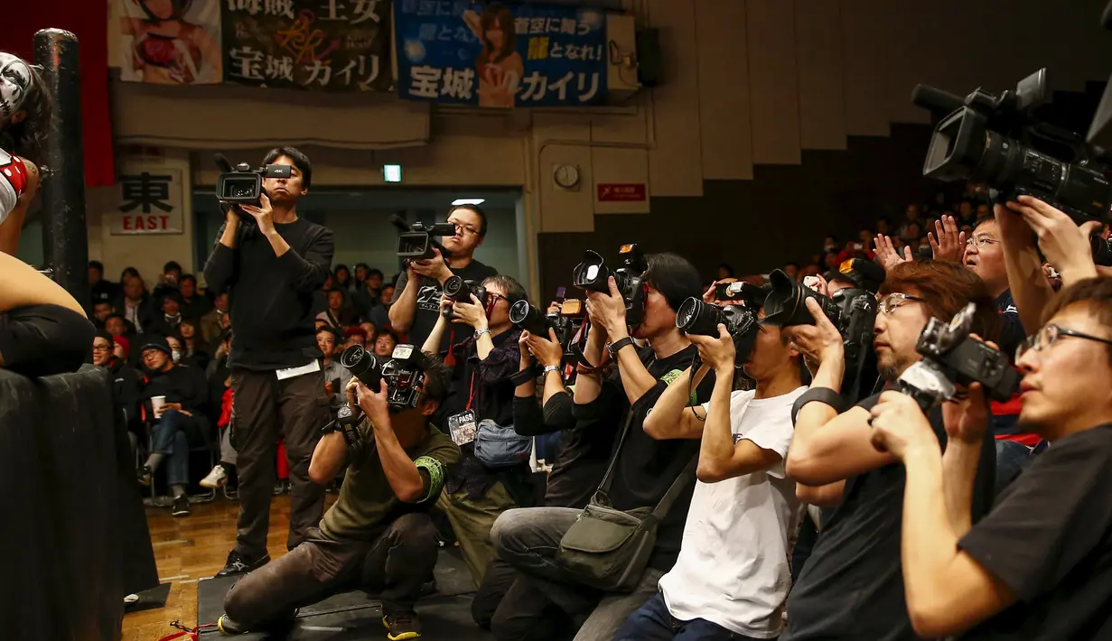 Sejumlah media saat menyoroti pertandingan gulat wanita di Korakuen Hall, Tokyo , Jepang , (23/12/2015).  Hampir semua  penonton gulat wanita ini merupakan laki-laki. (REUTERS / Thomas Peter)