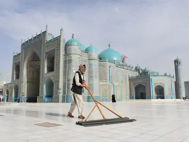 Seorang pria membersihkan halaman depan Masjid Biru di Mazar-i-Sharif, ibu kota Provinsi Balkh, Afghanistan utara (11/7/2020). Setelah lima bulan ditutup akibat dampak pandemi COVID-19, Masjid Biru baru-baru ini telah dibuka kembali untuk umum. (Xinhua/Kawa Basharat)