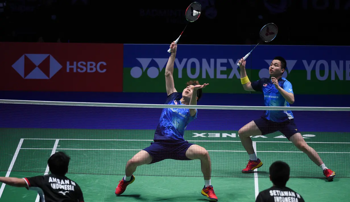 Aksi ganda putra Malaysia, Aaron Chia/Soh Wooi Yik di laga final All England 2019 yang berlangsung di Arena Birmingham, Minggu (10/3). Di final Aaron Chia/Soh Wooi Yik kalah 11-21, 21-14, 21-12 dari Hendra/Ahsan. (AFP/Oli Scarff)