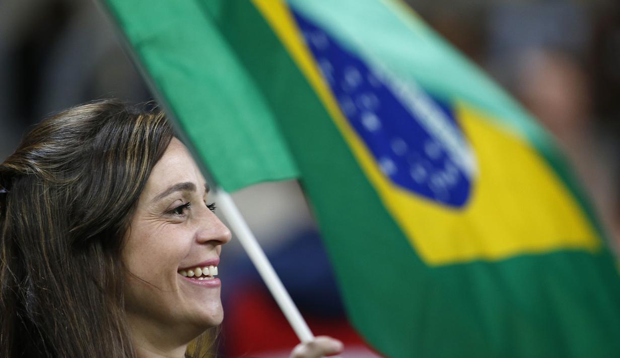 Suporter Brasil mengibaran bendera saat mendukung timnya melawan Ekuador pada laga kualifikasi Piala Dunia 2018 zona CONMEBOL di Porto Alegre, Brasil, (31/8/2017). Brasil menang 2-0.  (AP/Leo Correa)