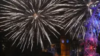 Kembang api memancar di sekitar The Elizabeth Tower, juga dikenal sebagai 'Big Ben' dan London Eye saat perayaan Tahun Baru di London, Inggris (1/1/2016). (AFP Photo / Justin Tallis)