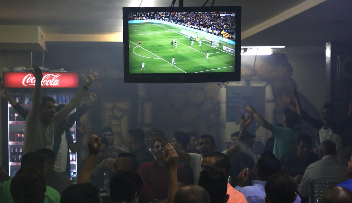 Warga Palestina menonton laga El Clasico antara Barcelona melawan Real Madrid di West Bank City, Ramallah, Minggu (6/5/2018). Konflik perang tak menyurutkan fenomena El Clasico. (AFP/Abbas Momani)